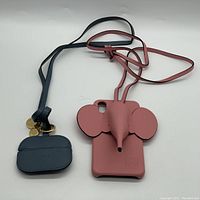 Photo showing pink elephant-shaped phone case and small dark blue pouch with straps