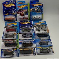 Front view of all 15 Hot Wheels cars in original packaging arranged in rows. Visible models include muscle cars, trucks and other designs.