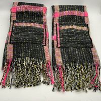 Two fringe blanket scarves folded neatly showing front pockets and fringed edges, patterned in black, yellow, and fuchsia plaid.