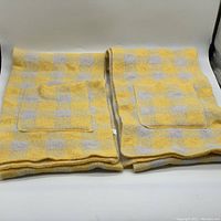 Yellow and gray plaid knit scarf showing front pockets and knit texture