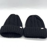 Two black wide rib knit beanies side by side showing front folded brim with BP brand labels.