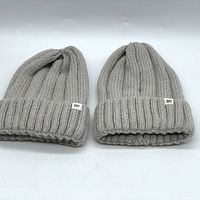 Two grey BP brand wide rib knit beanies displayed side by side, showing the texture, color, and BP branding tag on each.