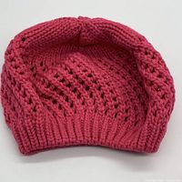 Single pink yarrow color open knit beret showing overall shape and knit pattern.