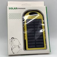 Front of box showing solar charger visible through window, yellow and black device with solar panel and LED torch