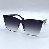 Front angled view showing black cat eye frame with gradient lenses and QUAY logo on lens