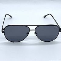 Front view of black metal frame aviator sunglasses with dark polarized lenses and Quay logo on right lens.