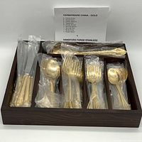 Full view of the flatware set in a wooden organizer tray, items wrapped in clear plastic; note card listing included pieces.