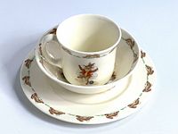 Full view of the three-piece Bunnykins set stacked: cup, bowl, and plate showing general condition and design.