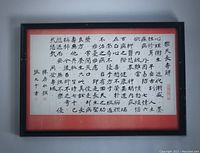 Full view of framed calligraphy artwork showing red mat, black frame, glass front