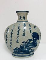 Front view of off-white blue and white porcelain vase showing Chinese calligraphy and a detailed illustration of a reclining man under a tree.