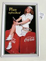 Full front view of the Coca-Cola tin sign featuring a retro tennis-themed advertisement with a woman in white tennis attire holding a bottle of Coke.