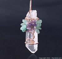 Front view of handmade pendant showing clear quartz point wrapped with copper wire and decorated with tumbled 7 chakra gemstones in a tree of life design.