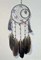 Front view of handmade vintage dream catcher showing full details including feathers, tassels, heart charm, butterflies, and bells.