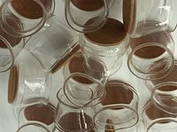 Close-up photo showing multiple transparent plastic chair leg covers with felt bottoms stacked together.