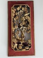 Front view of the antique gilt wood panel showing intricate bird and floral carving with red background and visible crack.