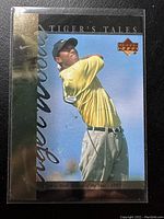 Front of the Tiger Woods sports card showing Tiger mid-swing with gold and black accent design.