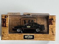 Front view of the unopened black 1988 Ford Mustang GT S45 diecast model in original M2 Machines box with Lunati Bootlegger branding.