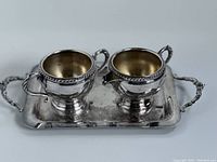 Silverplate cream and sugar cups on serving tray, showing gadroon edge detail and polished finish.