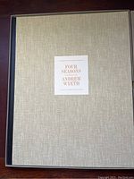 Closed beige linen portfolio slipcase with centered white label reading FOUR SEASONS ANDREW WYETH