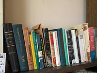 Row of hardcover and paperback geography books on shelf, titles visible