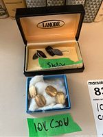Overall shot showing both sterling and gold cufflink pairs in their respective boxes