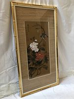 Framed watercolor painting on silk featuring flowers and birds, bamboo style frame visible.
