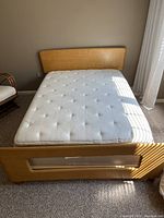 Full size bed with wooden headboard and footboard, mattress on top.