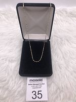 Front view of the gold over sterling silver chain necklace in a black velvet-lined jewelry box.