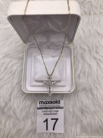 Front view of gold over sterling silver cross pendant necklace in white presentation box, showing clear zirconia crystals