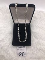 Figaro chain necklace displayed standing vertically in a black jewellery box with white interior.