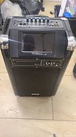 Front view of the Pyle karaoke speaker showing large speaker grill, screen, and control panel on top.
