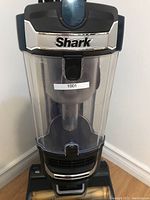 Front view showing transparent dust cup with Shark brand plate above and label '1001'.