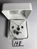Three-piece jewelry set in white box showing necklace, earrings, and ring with simulated mystic topaz stones.