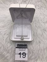 Sterling silver chain necklace with infinity symbol and Swarovski crystal pendant in a white jewelry box.