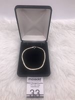 Sterling silver bracelet in black velvet box, showing the full bracelet inside the box on white fur.