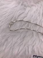 Close-up of sterling silver necklace clasp marked '925' indicating sterling silver.