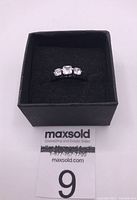 Photo of sterling silver ring with three clear round-cut zirconia stones in black jewelry box.