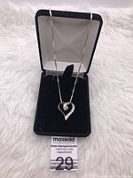 Sterling silver heart pendant necklace displayed in a black jewelry box, shown from two slightly different angles.