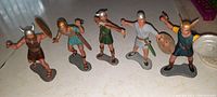 Group photo of five Marx 6-inch tall hard plastic warrior figures from the 1970s, each holding weapons such as swords, shields and pistol, standing on individual bases.