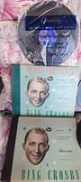 Photo of two Bing Crosby albums with cover portraits and Decca Records logo, along with a record in a plastic sleeve.