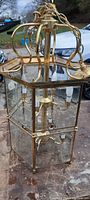 Overall view of brass framed hanging ceiling lamp with beveled glass panels and chain hanger.