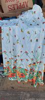 Full view of the dress showing white silk fabric with floral and bird print.