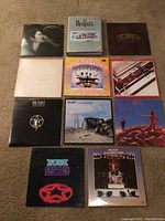 Full view of all Beatles and Rush vinyl albums laid out on carpet