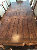 Top-down view of extended table showing wood plank pattern and decorative apron