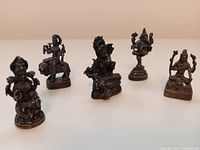 Five miniature bronze Hindu deity sculptures displayed in a row, showing their relative sizes and intricate details