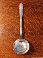 Top view of the silver ladle showing bowl and handle with Art Deco pattern