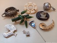 Photo showing all 9 vintage brooches and pendants together on a flat surface.