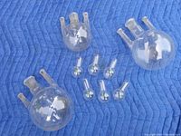 Top view showing three large round bottom boiling flasks with two side necks and six small beakers arranged on padded fabric.