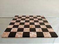 View of chess board showing alternating pink and black marble squares with no visible damages.