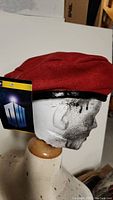 Close-up of red beret on mannequin head with Doctor Who tag